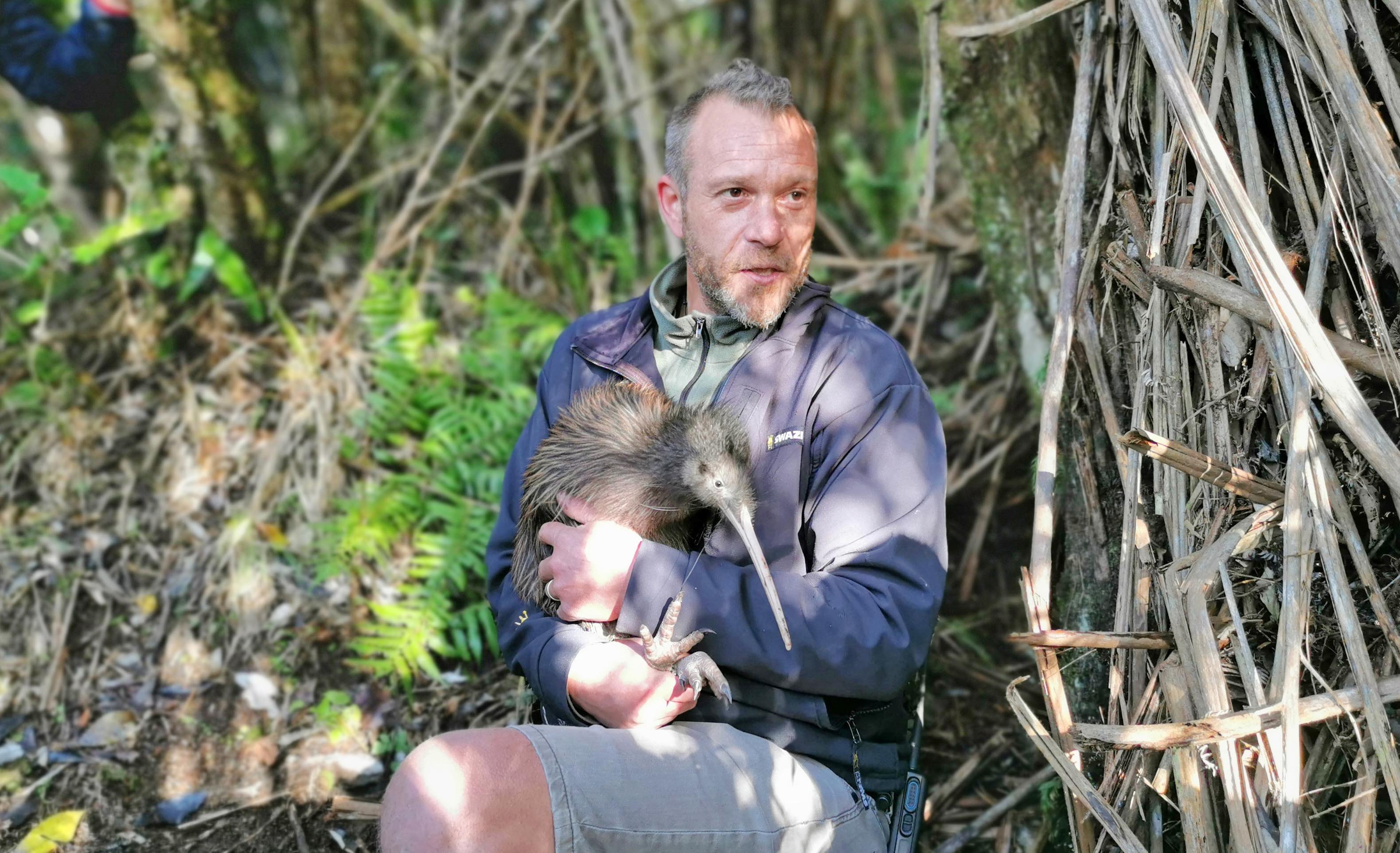 Rotokare Project Manager Simon Collins holding a kiwi